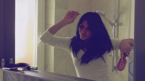 Happy woman dancing in bathroom while brushing long hair slow motion closeup Stock Footage 58737046