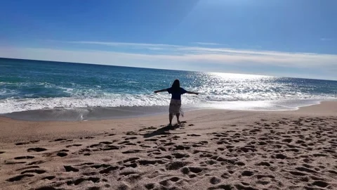Happy woman dancing in circle on the empty beach on sunny day, 4K Stock Footage 270745775