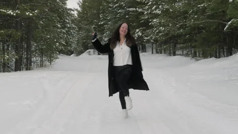 Happy woman dancing while having fun on snow covered landscape in forest Stock Footage 296677319