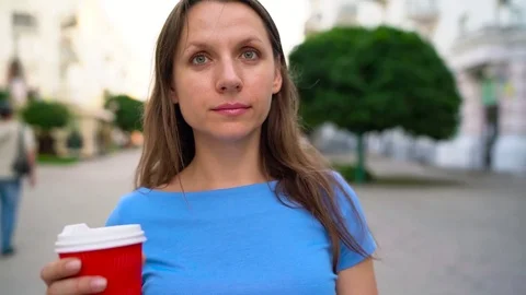 Happy woman drinking coffee on a busy street Stock Footage