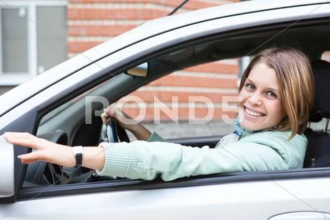 Happy woman on driver` s seat in own car Stock Photos