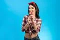 The happy woman eating a candy on the blue background Photo