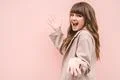 The happy woman gesturing on the pink wall background Photo