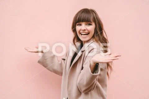 The happy woman gesturing on the pink wall background Stock Photos