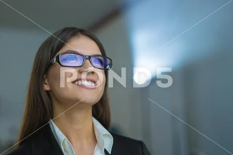 The happy woman with glasses on the background of projector Stock Photos
