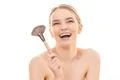 The happy woman holding a cosmetic brush on the white background Photo