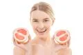 The happy woman holding a grapefruit on the white background Photo
