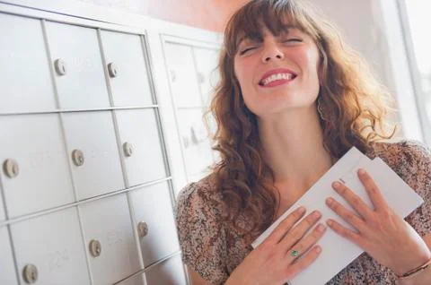 Happy woman holding letters near mail box Stock Photos