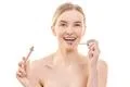 The happy woman holding a lip gloss on the white background Photo