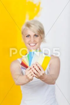 Happy woman holding out color samples Stock Photos
