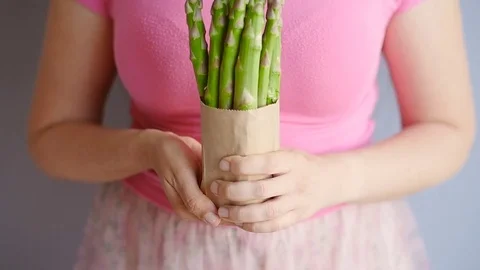 Happy woman holding showing asparagus in closeup Stock Footage