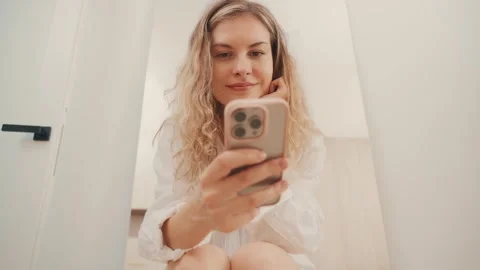 Happy woman holding using mobile phone in hands spends time on social media Stock Footage 311575488