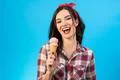 The happy woman with an ice cream on the blue background Photo