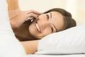 The happy woman lay on the bed and phone Photo