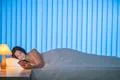 The happy woman lay on the bed and phone. Evening night time Photo