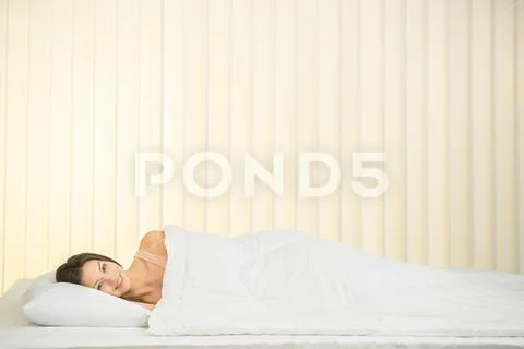 The happy woman lay on the bed Stock Photos