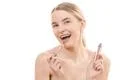 The happy woman with a lip gloss on the white background Photo