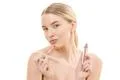 The happy woman with a lip gloss on the white background Photo