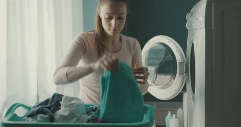 Happy woman loading the washing machine Stock Footage 151298282