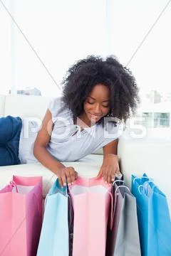 Happy woman looking into her shopping bags Stock Photos
