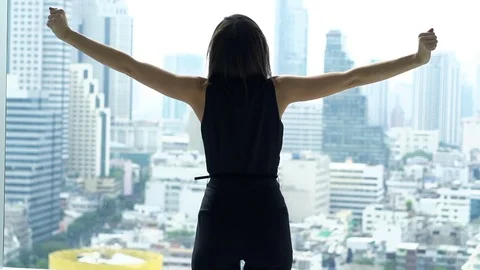 Happy woman raising arms standing by window at home, super slow motion 120fps Stock Footage