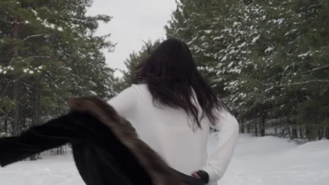 Happy woman removing jacket while running on snow covered pathway Stock Footage 296678241