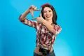 The happy woman with an retro camera standing on the blue background Photo