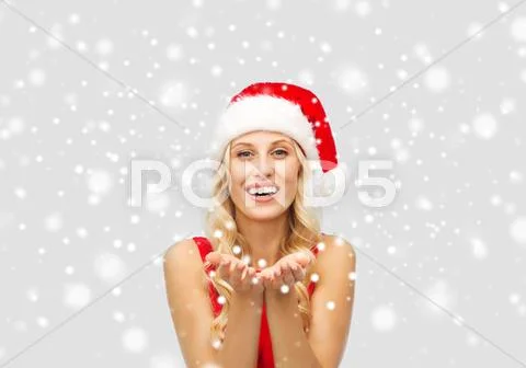 Happy woman in santa hat holding something on palm Stock Photos