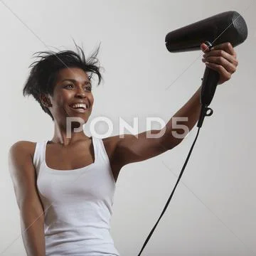 Happy woman with a short haircut and hair dryer Stock Photos