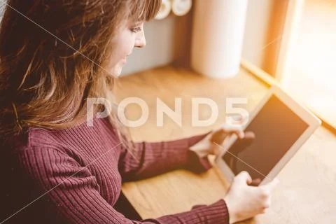 The happy woman sitting with a tablet in the restaurant Stock Photos