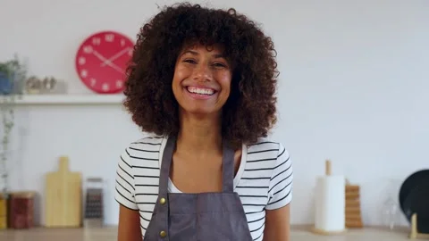 Happy woman smiling at camera while cooking healthy meal for dinner at home Stock Footage 303467568