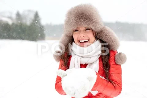 Happy woman with snow in winter fur hat outdoors Stock Photos