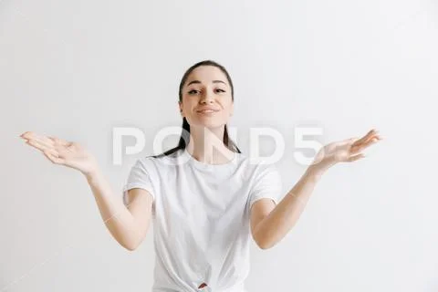 The happy woman standing and smiling against gray background. Stock Photos