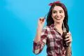 The happy woman standing with a bottle of drink on the blue background Photo