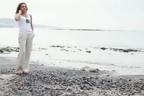 Happy woman standing by the sea, steadicam shot NTSC Stock Footage