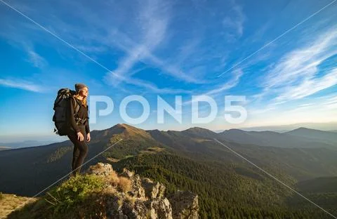 The happy woman standing on the sunny mountain Stock Photos