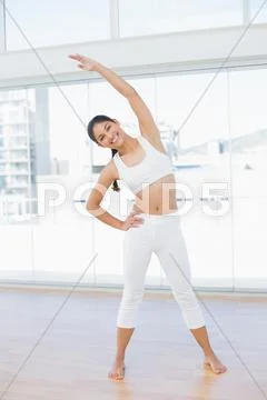 Happy woman stretching hand in fitness studio Stock Photos