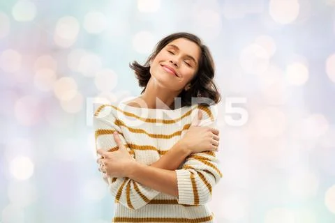 Happy woman in striped pullover hugging herself Stock Photos