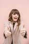 The happy woman thumbs up on the pink wall background Photo