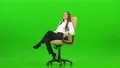 The happy woman turning on the office chair on the green background 4k or 4k+ Resolution