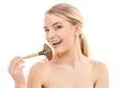 The happy woman using a cosmetic brush on the white background Photo