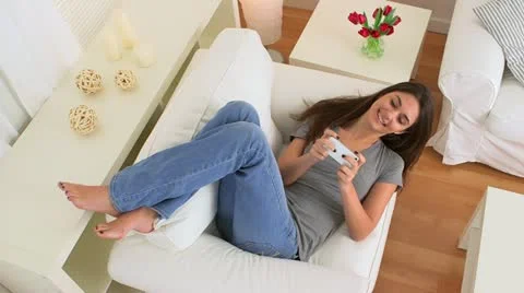 Happy woman using iphone on couch Stock-Footage 22341044