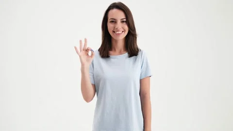 A happy woman wearing basic t-shirt is doing ok gesture to the camera  Stock Footage 157866845