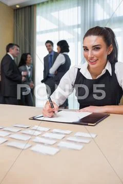 Happy woman at welcome desk Stock-Fotos