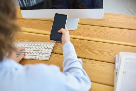 Happy woman working using multiple devices on a desk at home Stock Photos