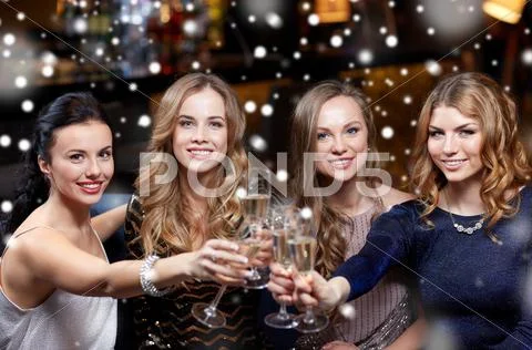 Happy women with champagne glasses at night club Stock Photos
