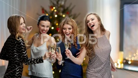 Happy women clinking champagne glasses over black Stock Photos