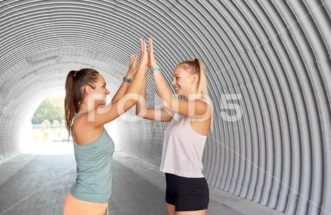 Happy women with fitness trackers making high five Stock Photos