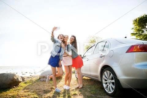 Happy Women Taking Selfie Near Car At Seaside