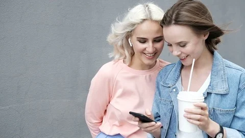 Happy women using smartphone together browsing online having fun Stock Footage 77965249
